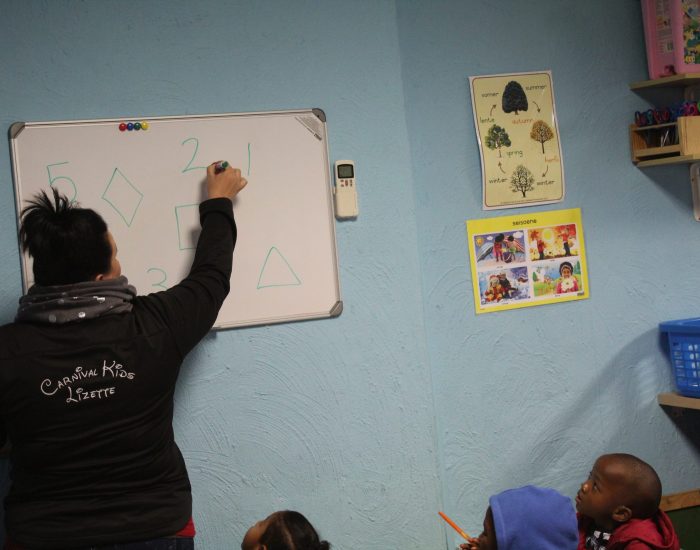 Canival Kids Private Preschool Classroom teacher writing on the board